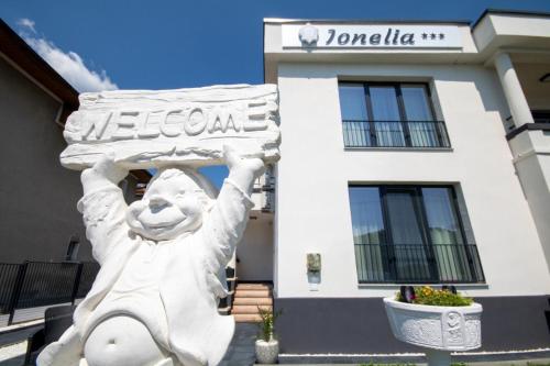 a statue of a man holding a sign in front of a building at Pensiunea Ionelia in Orşova