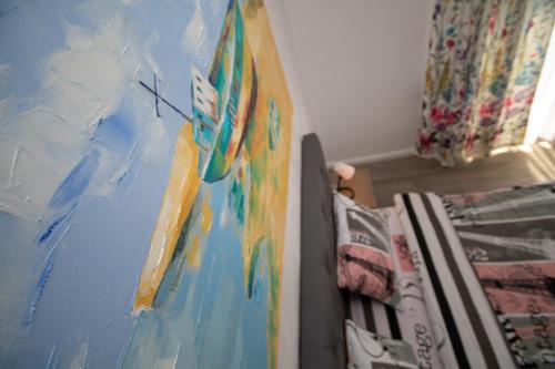 a bedroom with a painting on the wall next to a bed at Pensiunea Ionelia in Orşova