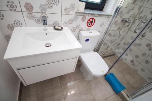 a bathroom with a sink and a toilet and a shower at Pensiunea Ionelia in Orşova