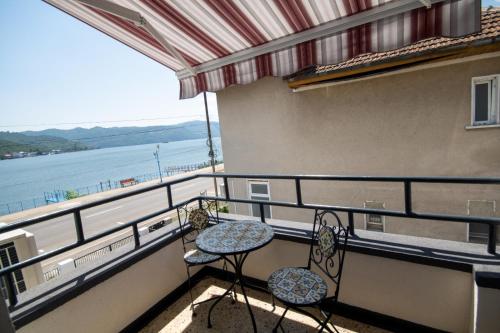 a balcony with two tables and a view of the water at Pensiunea Ionelia in Orşova