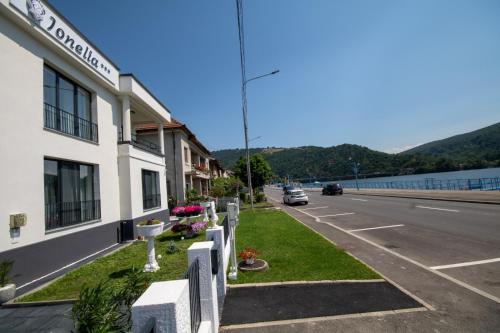 a building on the side of a road next to a street at Pensiunea Ionelia in Orşova