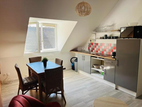 een keuken en eetkamer met een tafel en een koelkast bij Appartement Cosy en coeur de vieille ville in Boulogne-sur-Mer