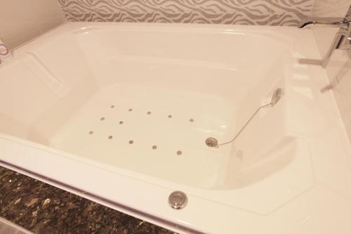a white bath tub sitting in a bathroom at Boutique Hotel SB Yeouido in Seoul