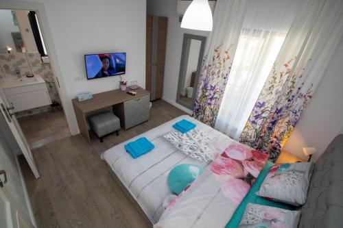a small living room with a bed and a desk at Pensiunea Ionelia in Orşova
