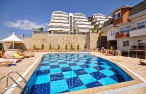 una piscina con azulejos azules en la parte lateral de un edificio en 4 N Suite en Alanya