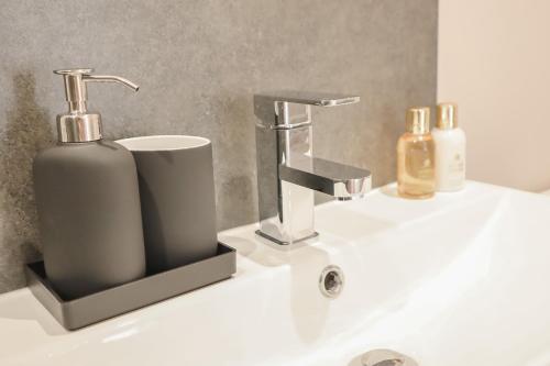 a bathroom sink with a soap dispenser on it at The Gardens Room in Upton