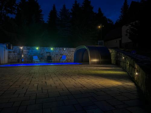 a patio at night with two chairs and lights at Resort LUFT Sněžník in Sněžnik