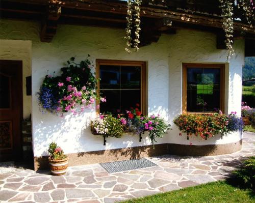 ein Haus mit Blumen auf der Seite in der Unterkunft Merryshof in Sankt Ulrich am Pillersee