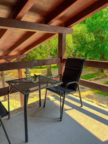 a glass table and a chair on a patio at Resort LUFT Sněžník in Sněžnik
