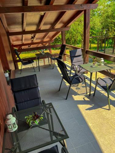 a patio with chairs and tables and a wooden roof at Resort LUFT Sněžník in Sněžnik