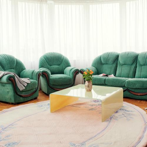 a living room with green chairs and a coffee table at Santorini in Chişinău