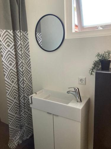 a bathroom with a sink and a mirror on the wall at Casa Bianco in Koudekerke