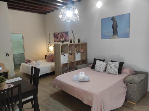 a living room with a couch and a bed and a table at Apartamento Loft Puerto de Gades in Cádiz