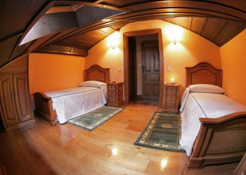 a large room with three beds in a room at Posada de Fidel in Puentenansa