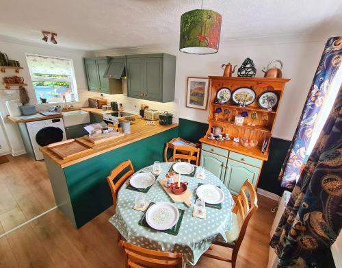 a kitchen with a table and a kitchen with a table and chairs at Chapel Bricks-dog friendly cottage near the coast in Withernwick