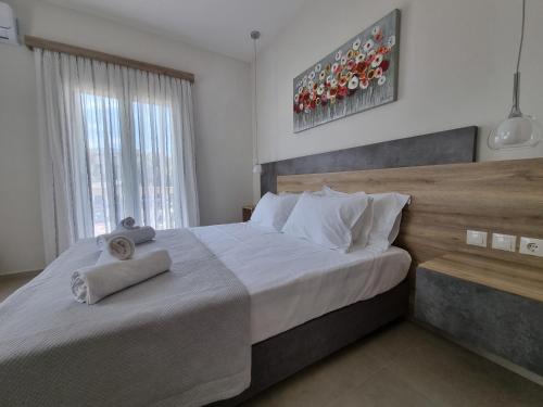 波羅斯的住宿－Chrysanthe's Apartments No1，一间卧室配有一张大床和两条毛巾