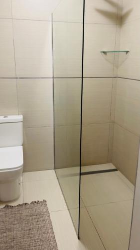 a bathroom with a glass shower with a toilet at Stay at 11 on Gull in Cape Town