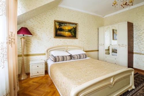 a bedroom with a bed and a painting on the wall at Santorini in Chişinău