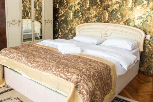 a bedroom with a large bed in a room with wallpaper at Santorini in Chişinău