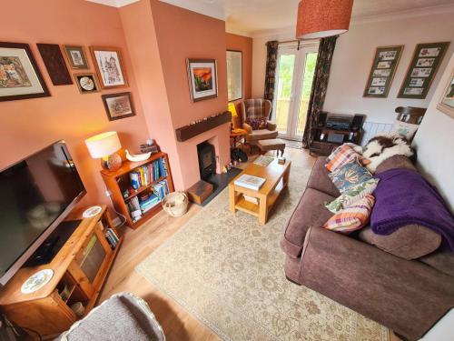 a living room with a dog sitting on a couch at Chapel Bricks-dog friendly cottage near the coast in Withernwick