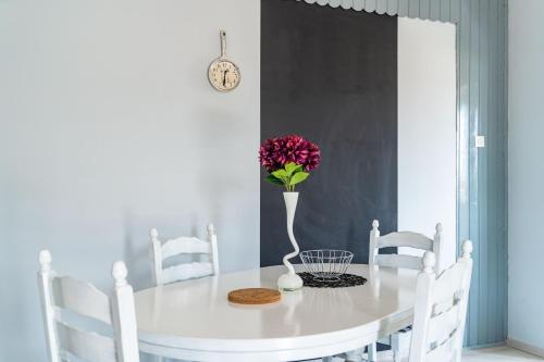 a white dining room table with a vase of flowers on it at Dubrovnik dream by Nostromo in Dubrovnik