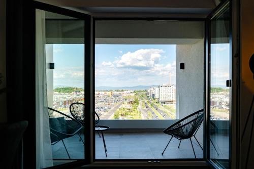 a balcony with chairs and a view of a city at Apart B&V 55 Qualis - Luxury Mountain Escape in Braşov