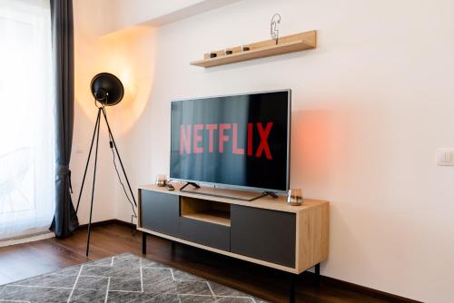 a television on a entertainment center in a living room at Apart B&V 55 Qualis - Luxury Mountain Escape in Braşov