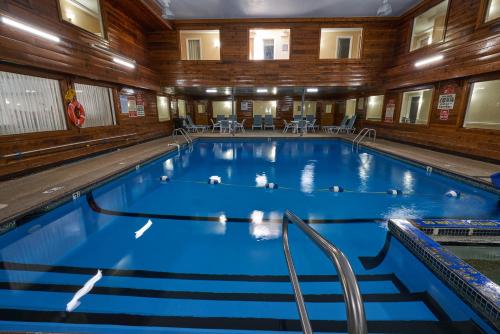 a large swimming pool with blue water in a building at Ambassador Inn and Suites in South Yarmouth