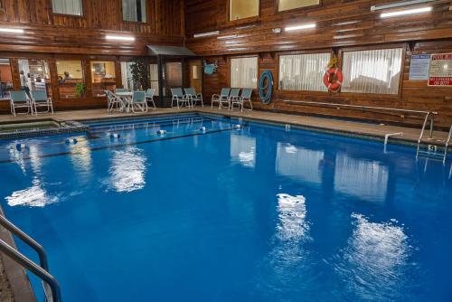 a large blue swimming pool in a building at Ambassador Inn and Suites in South Yarmouth
