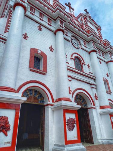 a white building with columns and a clock on it at Apartamento Centro Guatapé, parque y embalse in Guatapé
