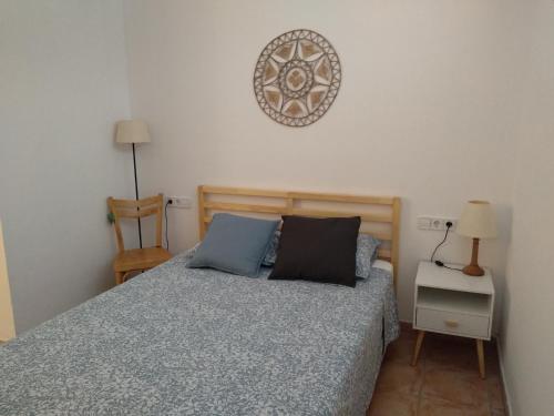 a bedroom with a bed and a clock on the wall at Pis a Sant Feliu de Guíxols in Sant Feliu de Guixols