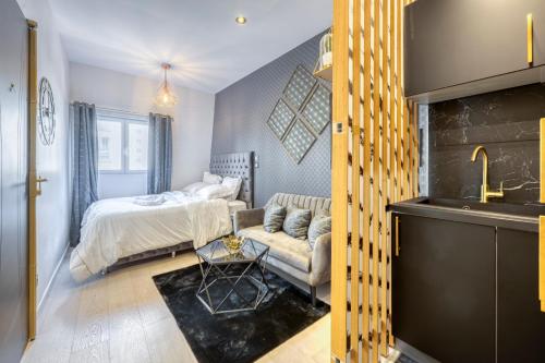 um quarto com uma cama, um sofá e um lavatório em Studio em Livry-Gargan