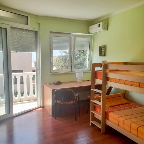 a bedroom with a desk and a bunk bed at Villa Rossa in Utjeha