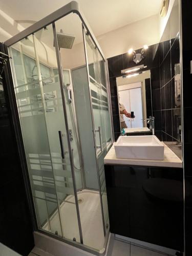 uma casa de banho com uma cabina de duche em vidro e um lavatório. em Cannes - view Cap Esterel em Cannes