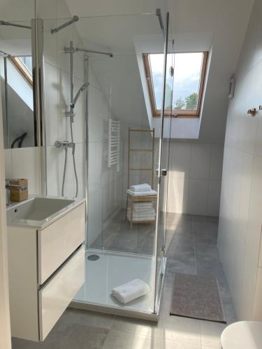 ein Bad mit einer Dusche und einem Waschbecken in der Unterkunft Apartament 26 in Dziwnów