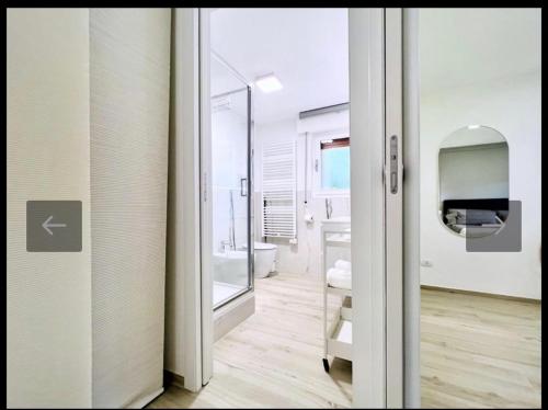 a bathroom with a glass door leading to a bathroom with a toilet at Lido Appartamento Parcheggio Privato 400 mt dal mare in Lido di Camaiore
