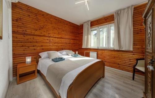 a bedroom with a large bed and a wooden wall at Apartmani Kraljevica in Kraljevica