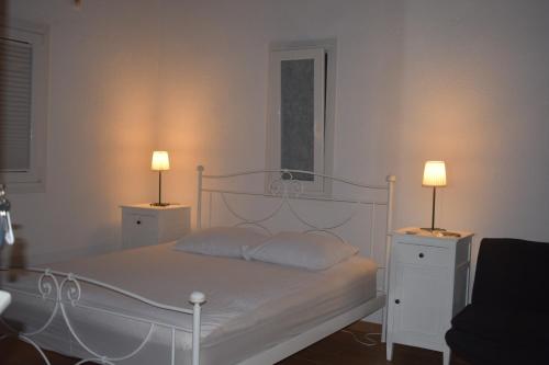 a bedroom with a bed with two lamps on it at Pool Guesthouse in Korinthos