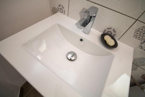 a white sink with a faucet in a bathroom at Pensiunea Ionelia in Orşova