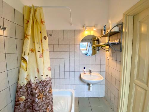 a bathroom with a sink and a shower curtain at Goldschmiedt Vendégház in Pálköve