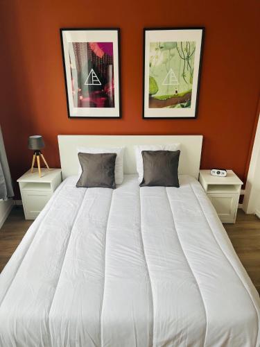 Cette chambre comprend un grand lit blanc et deux tables. dans l'établissement Chez Chromatique, 2 pers, hyper centre-ville, à Boulogne-sur-Mer