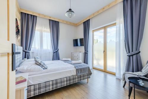 a bedroom with a bed and a large window at Panocek i Babka in Białka Tatrzanska