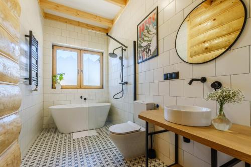 a bathroom with a tub and a toilet and a sink at Panocek i Babka in Białka Tatrzanska