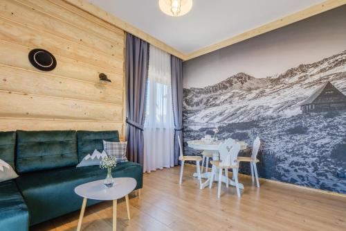 a living room with a green couch and a table at Panocek i Babka in Białka Tatrzanska