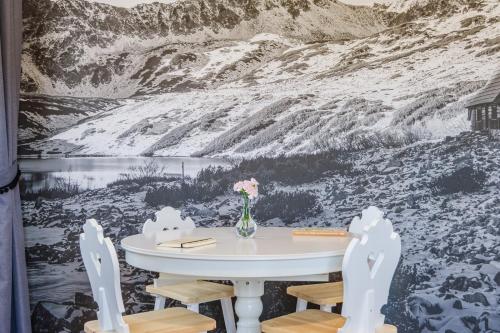 a dining room with a snow covered mountain mural at Panocek i Babka in Białka Tatrzanska