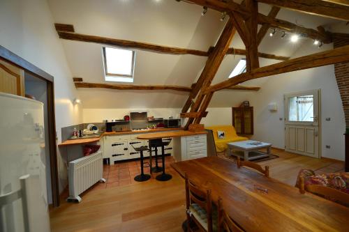 a large kitchen with wooden floors and wooden beams at Gîte de la vallée in Saint-Hilaire-la-Gravelle