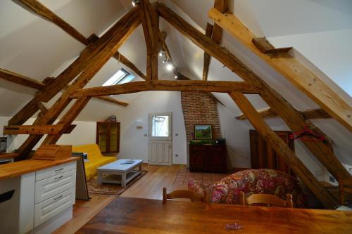 Gîte de la vallée في Saint-Hilaire-la-Gravelle: غرفة معيشة بسقوف خشبية وعوارض خشبية