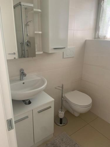 bagno bianco con lavandino e servizi igienici di Obsthof Klotz a Frangarto