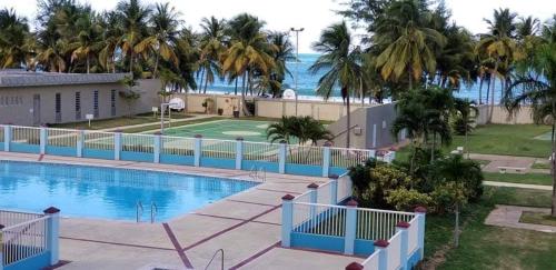a view of a swimming pool with the ocean in the background at Playa Azul II 302 in Luquillo
