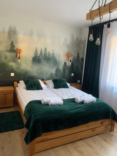 a bedroom with a large bed with towels on it at Domek na Malniku in Muszyna